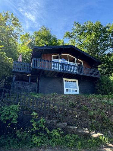 a house with a balcony on top of a hill at Chalet Alpin Suisse Au Bord Du Lac in Morin Heights