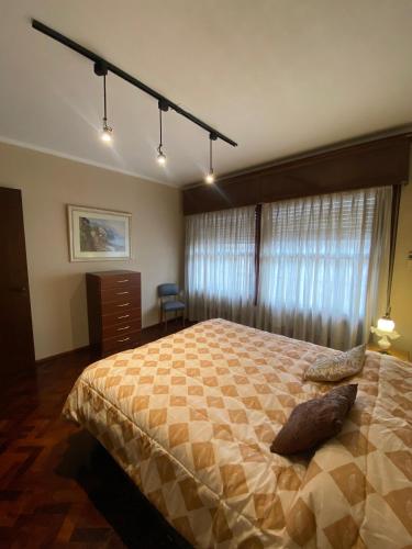a bedroom with a large bed and a window at Departamento Espejo in Mendoza