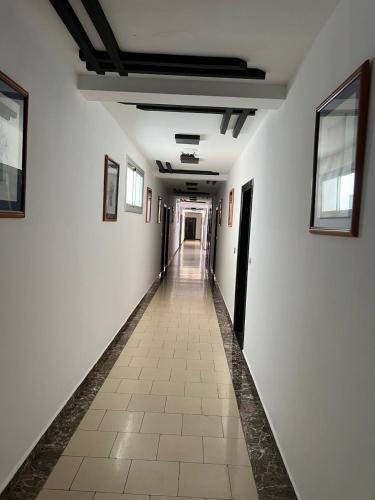 a long hallway with white walls and a tile floor at Solmar Apartments Oued Lou in Oued Laou