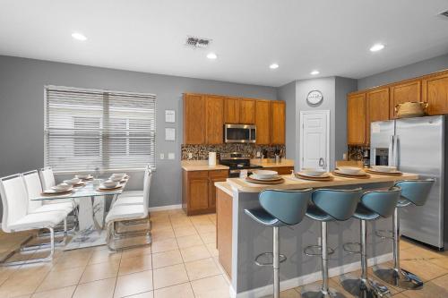 a kitchen with a table and chairs and a refrigerator at Lux 4BrVilla Hot Tub Grill Private Heated Pool in Kissimmee