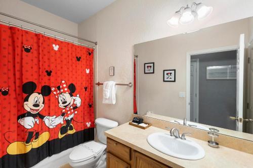 a bathroom with a shower curtain with mickey mouse on it at Lux 4BrVilla Hot Tub Grill Private Heated Pool in Kissimmee