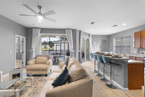 a living room with a couch and a kitchen at Lux 4BrVilla Hot Tub Grill Private Heated Pool in Kissimmee