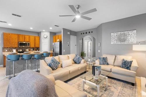 a living room with two couches and a kitchen at Lux 4BrVilla Hot Tub Grill Private Heated Pool in Kissimmee