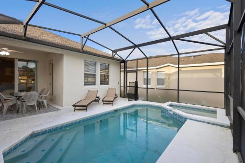 a swimming pool with a glass roof over a house at Lux 4BrVilla Hot Tub Grill Private Heated Pool in Kissimmee