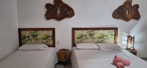 two beds in a room with white walls at Espaço Sairé - 8 minutos da Praia in Alter do Chao