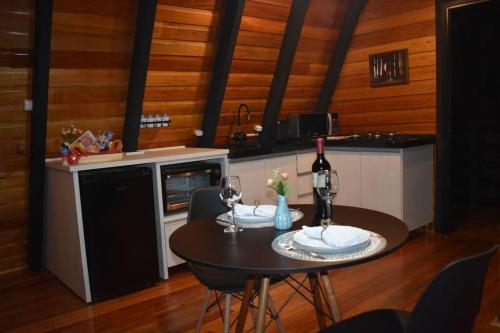 a kitchen with a table with two glasses of wine at Chalé das Laranjeiras in Planalto