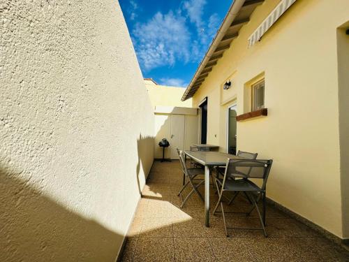 un patio avec une table et des chaises à côté d'un bâtiment dans l'établissement Maison cosy avec grande terrasse, proche quais et plages - Port-Vendres - FR-1-309-203, à Port-Vendres