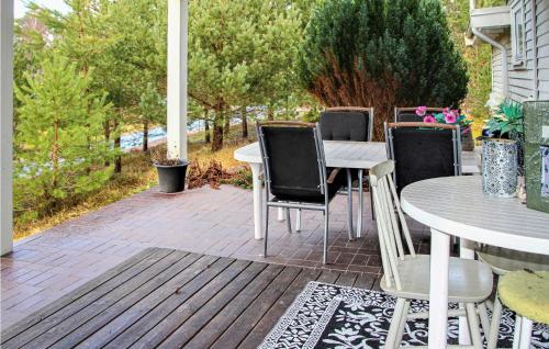 a patio with a table and chairs on a deck at Amazing Home In Båstad With Wifi in Båstad
