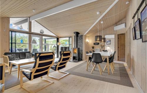 a dining room and living room with a table and chairs at Holiday Home Jægerens Vej in Blokhus