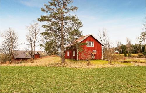 a red barn sitting on top of a lush green field at Nice Home In Ulrichamn With Wifi in Ulricehamn