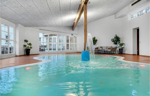 a swimming pool with blue water in a building at Lovely Home In Vorbasse With Kitchen in Vorbasse