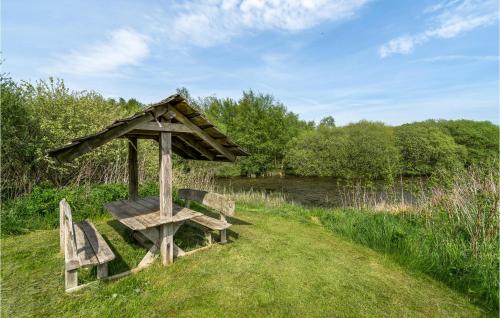 a bench with a gazebo next to a river at Lovely Home In Vorbasse With Kitchen in Vorbasse