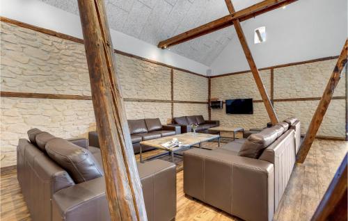 a room with leather furniture and a stone wall at Lovely Home In Vorbasse With Kitchen in Vorbasse