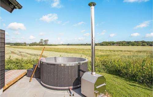 a hot tub on a deck next to a field at 4 Bedroom Nice Home In Odder in Odder