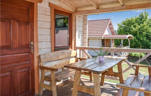 a wooden porch with a wooden bench and a table at Nice Home In Wejdyki With Sauna in Wejdyki