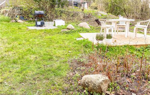 a yard with two chairs and a table in the grass at 1 Bedroom Awesome Home In Frillesås in Frillesås