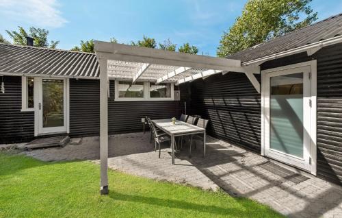 um pátio com uma mesa e uma pérgola em Two-Bedroom Holiday Home In Ulfborg em Ulfborg
