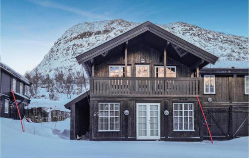 a log cabin in the snow with a mountain at Beautiful Home In Hovden I Setesdal in Hovden