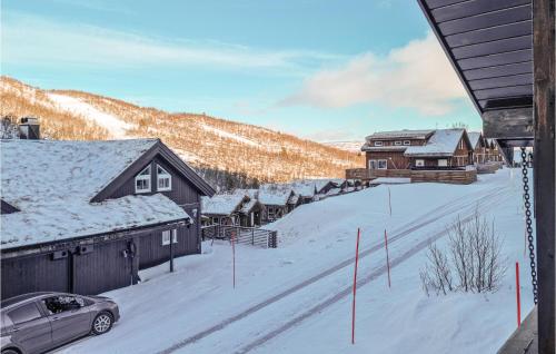 a snow covered village with houses and a car parked at Beautiful Home In Hovden I Setesdal in Hovden