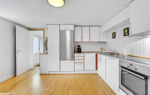 a kitchen with white cabinets and a wooden floor at Lovely Apartment In Skjern With Wifi in Skjern