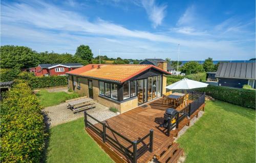 a house with a deck with a table and benches at Holiday Home Egevej Broager in Broager