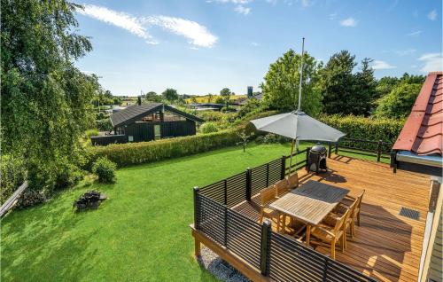 una terrazza in legno con tavolo e ombrellone di Holiday Home Egevej Broager a Broager