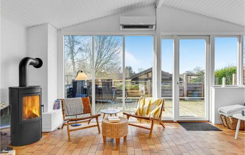 a living room with a fireplace and some chairs at Holiday Home Egevej Broager in Broager