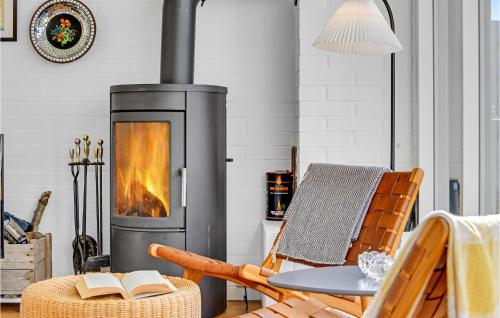 a fireplace in a living room with a chair and a table at Holiday Home Egevej Broager in Broager