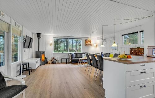 イェリングにあるAwesome Home In Hjørring With Wifiのテーブルと椅子のあるキッチンとリビングルーム