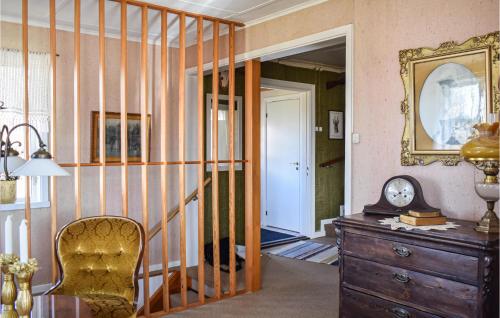 a room with a chair and a dresser and a mirror at Gorgeous Home In Burseryd With Kitchen in Sjötofta