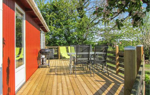 a deck with chairs and a grill on a house at Hus 24 in Allinge