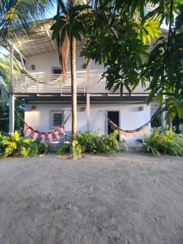 a house with a hammock in front of it at Morada da Joana Residence in Praia de Moitas