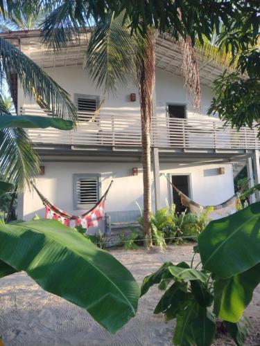 a house with a hammock in front of it at Morada da Joana Residence in Praia de Moitas