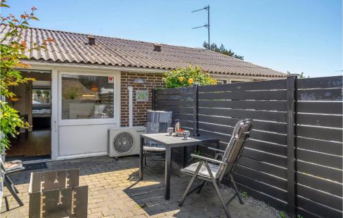 a patio with a table and chairs in front of a fence at Holiday Home Bl in Blåvand