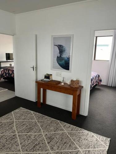a room with a table and a picture of a bird on the wall at T Two Salty Shack - right across from the beach! in Papamoa