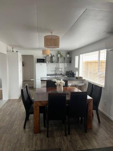 a kitchen and dining room with a table and chairs at T Two Salty Shack - right across from the beach! in Papamoa
