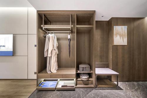 a walk in closet with a wooden wall at Howard Johnson Royal Hotel Shenzhen in Bao'an