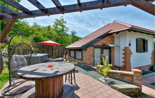 a table and chairs in a garden with a small house at Lovely Home In Beretinec With Wifi in Beretinec
