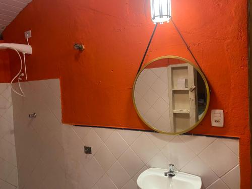 a bathroom with a mirror and a sink at Pousada Encanto das Águas in Ilhabela