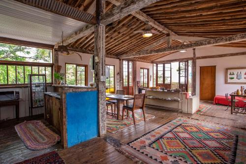 a living room with a table and a dining room at Pousada Encanto das Águas in Ilhabela