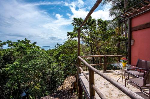 a balcony of a house with a table and chairs at Pousada Encanto das Águas in Ilhabela