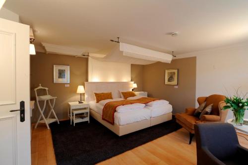 a bedroom with a bed and a couch and a chair at Altes Amtshaus, 3-Sterne Hotel Garni Superior in Mulfingen-Ailringen