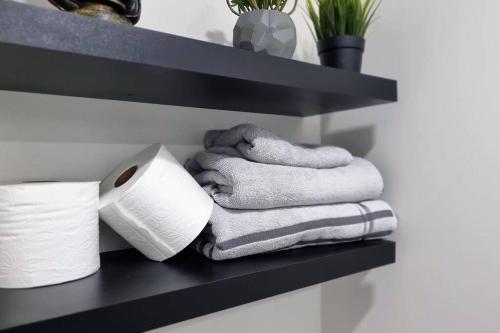 a shelf with towels and a roll of toilet paper at Moons & Noons -Separate Unit for your Comfort in Ajax