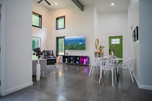 una sala de estar con una mesa y sillas en Secluded, Unique, Modern, Mountain Home Near River!, en Meadows of Dan