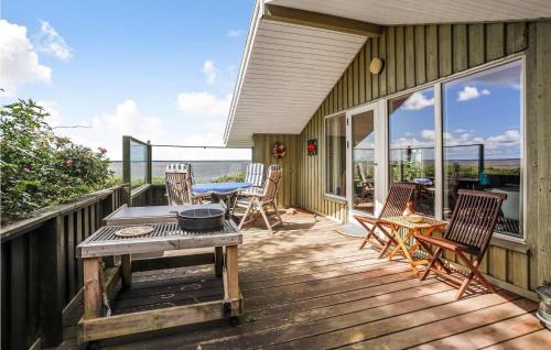 a wooden deck with a table and chairs on it at Gorgeous Home In Esbjerg V in Esbjerg
