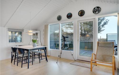a dining room with a table and chairs and windows at Gorgeous Home In Esbjerg V in Esbjerg