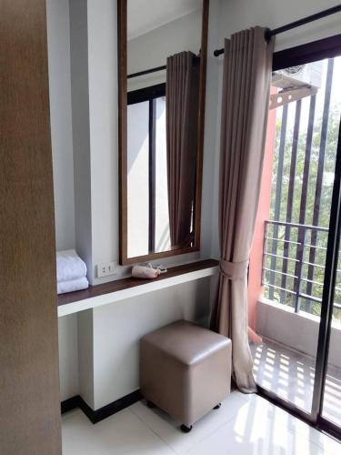 a room with a window with a stool in front of it at Bangkok Boutique Resort Rangsit in Pathum Thani