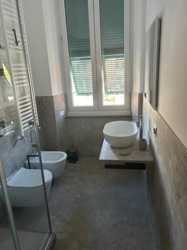 a bathroom with two sinks and a toilet and a window at Ulivo House in Genova