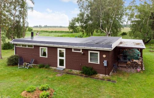 a small house with a solar roof on a field at Amazing Home In Stege With Kitchen in Stege