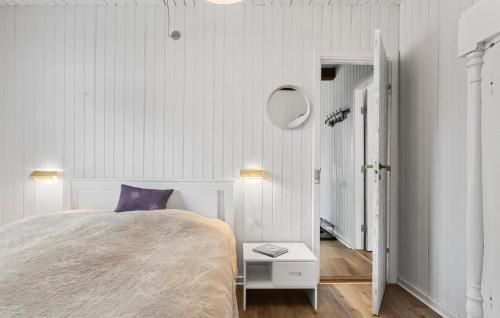 a white bedroom with a bed and a purple pillow at Amazing Home In Stege With Kitchen in Stege